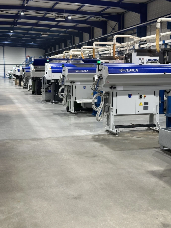 Atelier d’usinage CNC automatisé avec chargeurs de barres et machines interconnectées pour production en série.